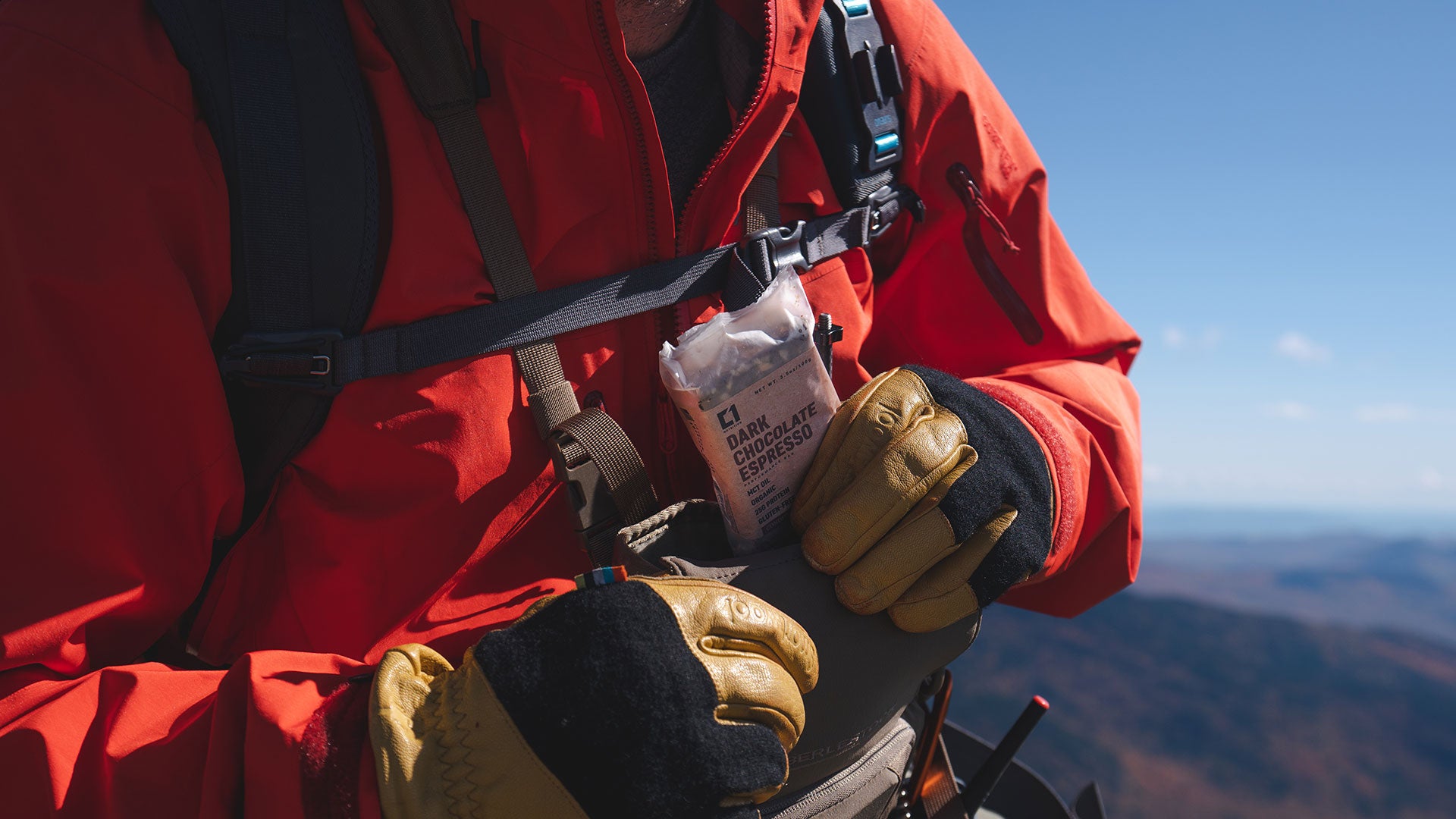 Person removing a C1 bar from an admin pouch on their hiking gear.