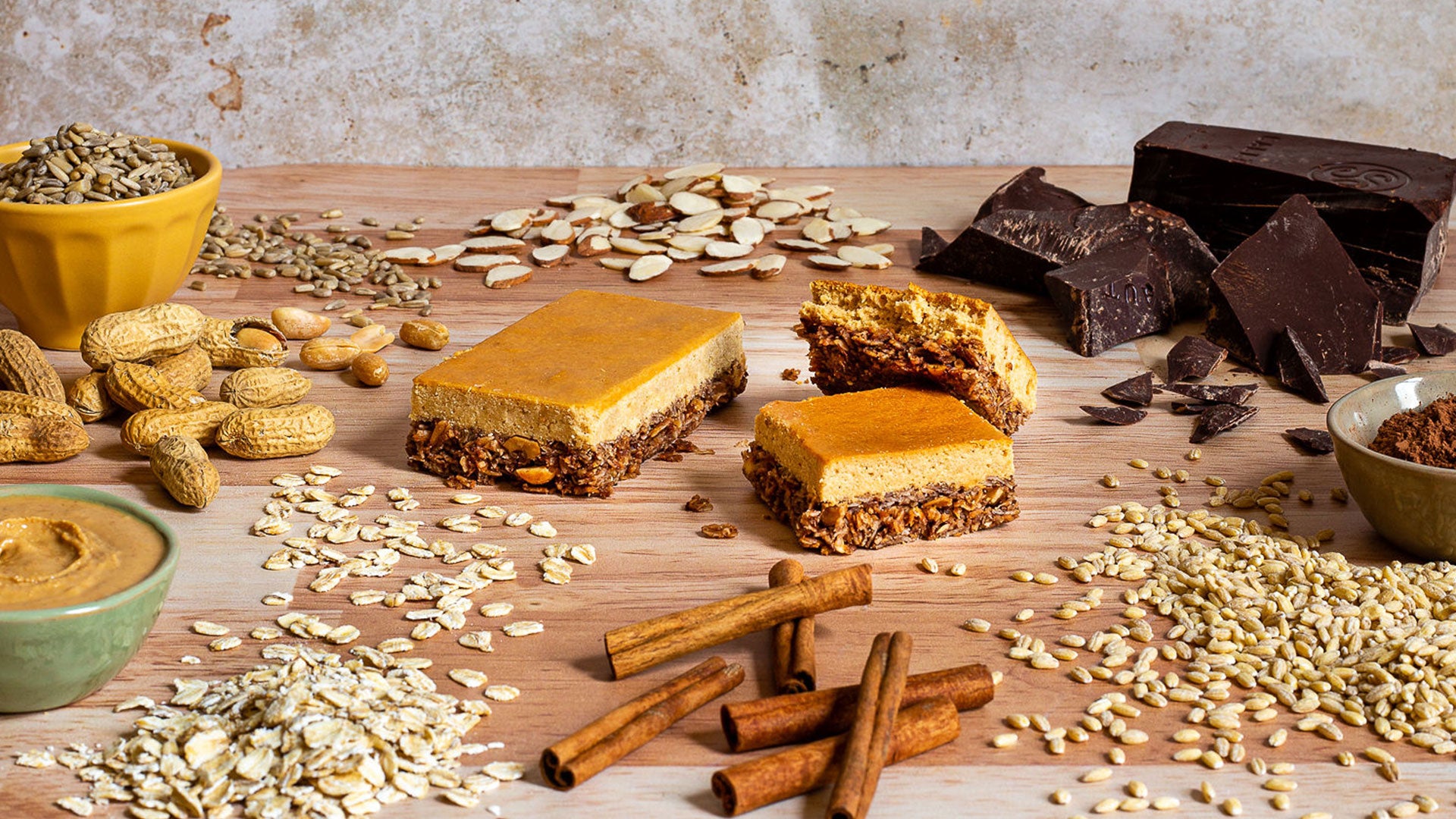 Peanut Butter Chocolate protein bar surrounded by whole food ingredients such as peanuts, almonds, oats, and flaxseed.
