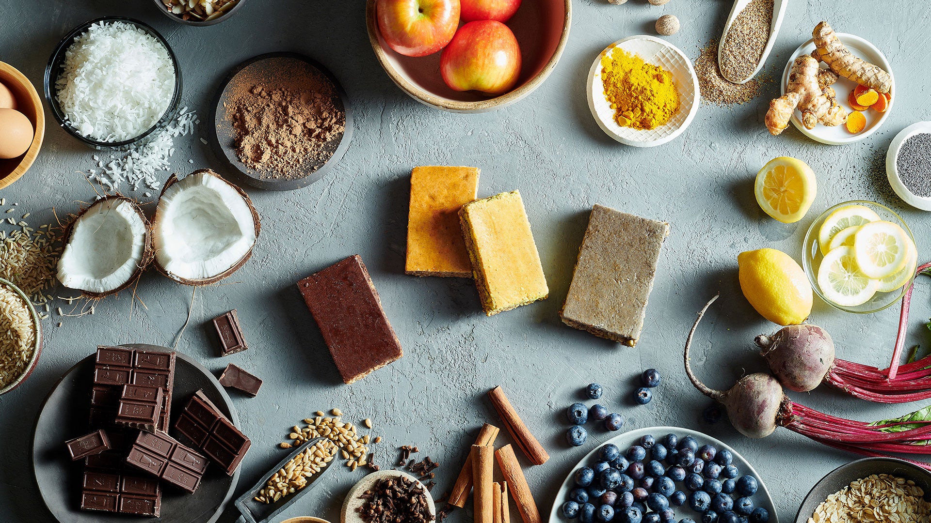 Four Condition One Nutrition bars spread out amongst their whole food ingredients.