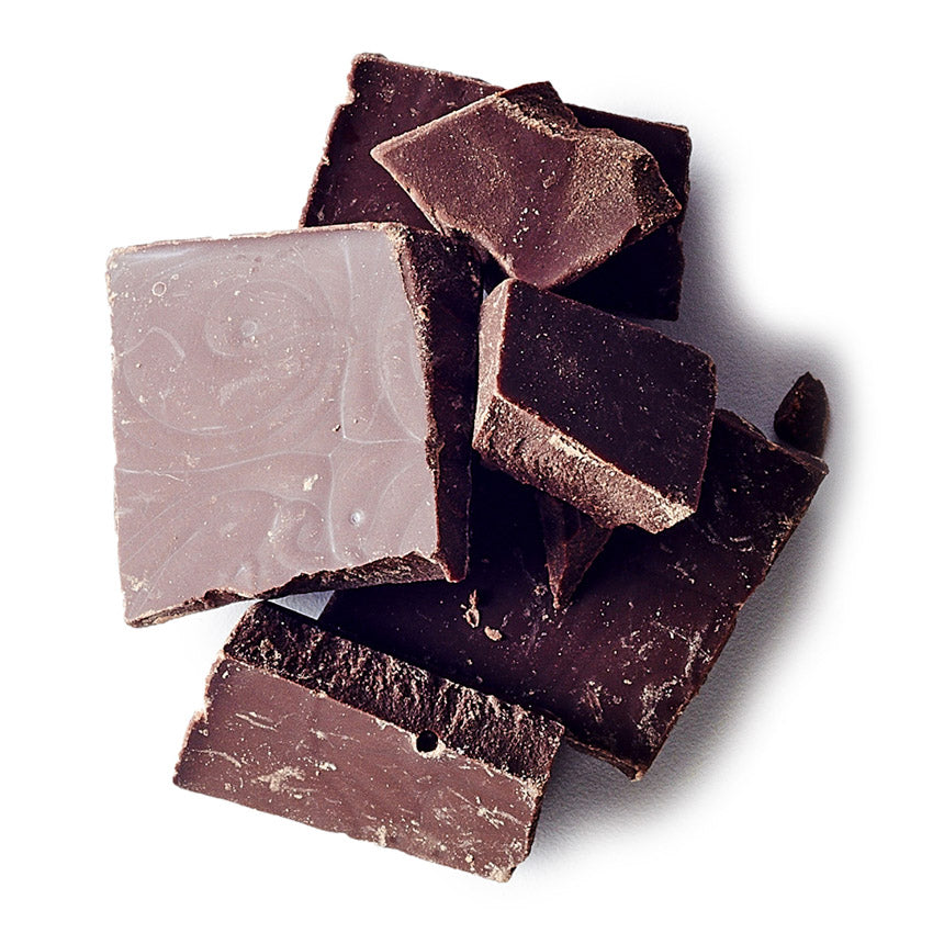 Dark chocolate pieces on a white background