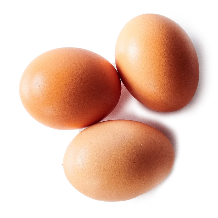 Three brown eggs on a white background
