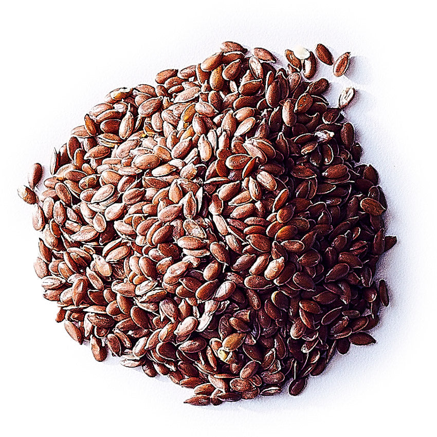 Pile of brown flax seeds on a white background