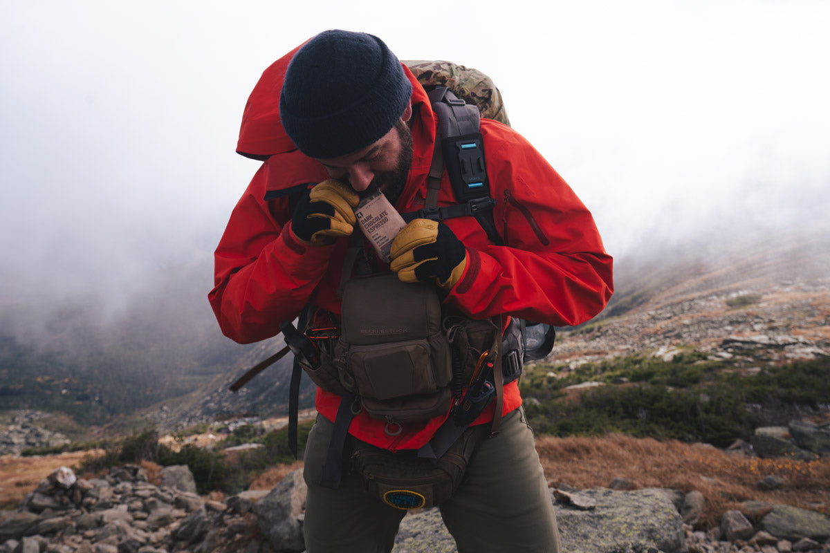 Matt DeMaio eating a dark chocolate espresso Condition One Nutrition protein bar on a mountain hike