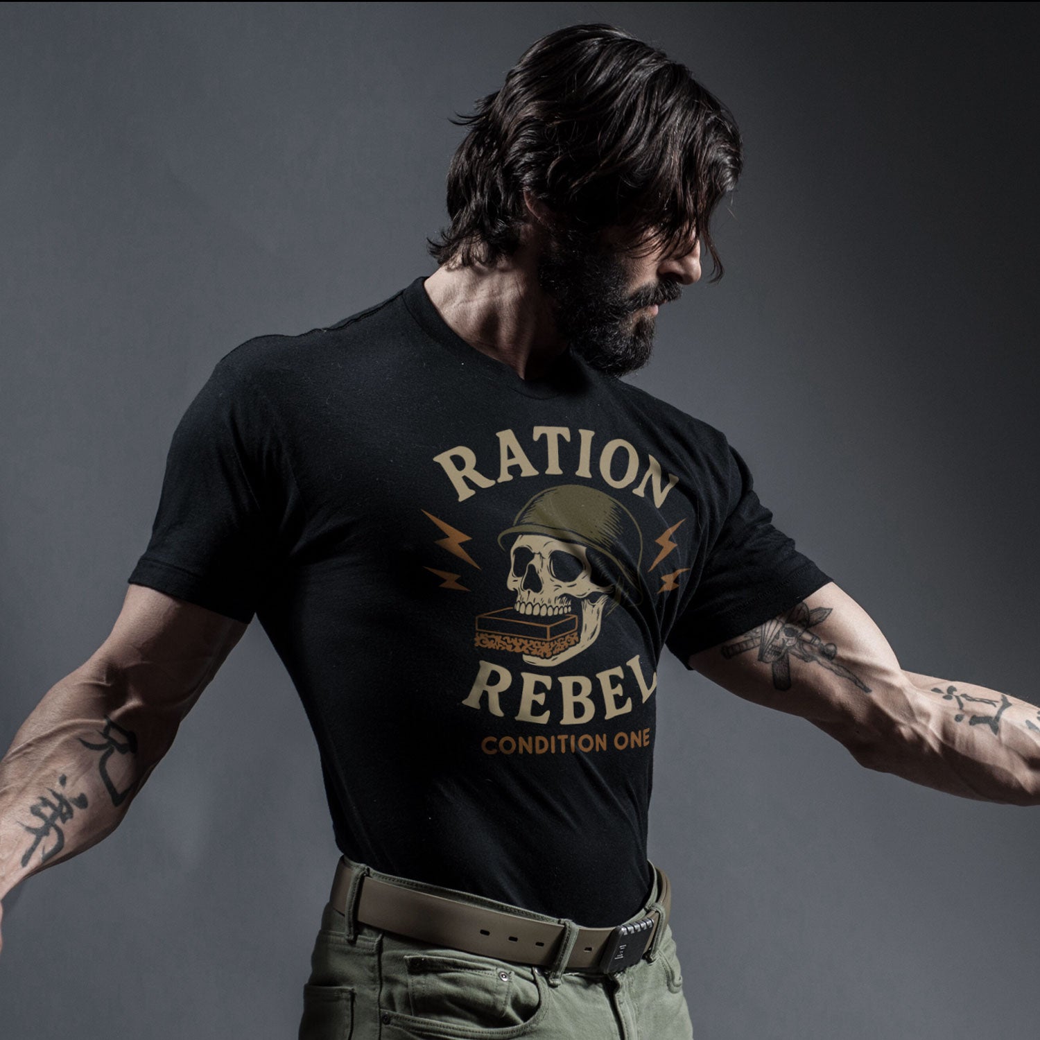Rudy Reyes wearing a black t-shirt with 'Ration Rebel' design against a dark background