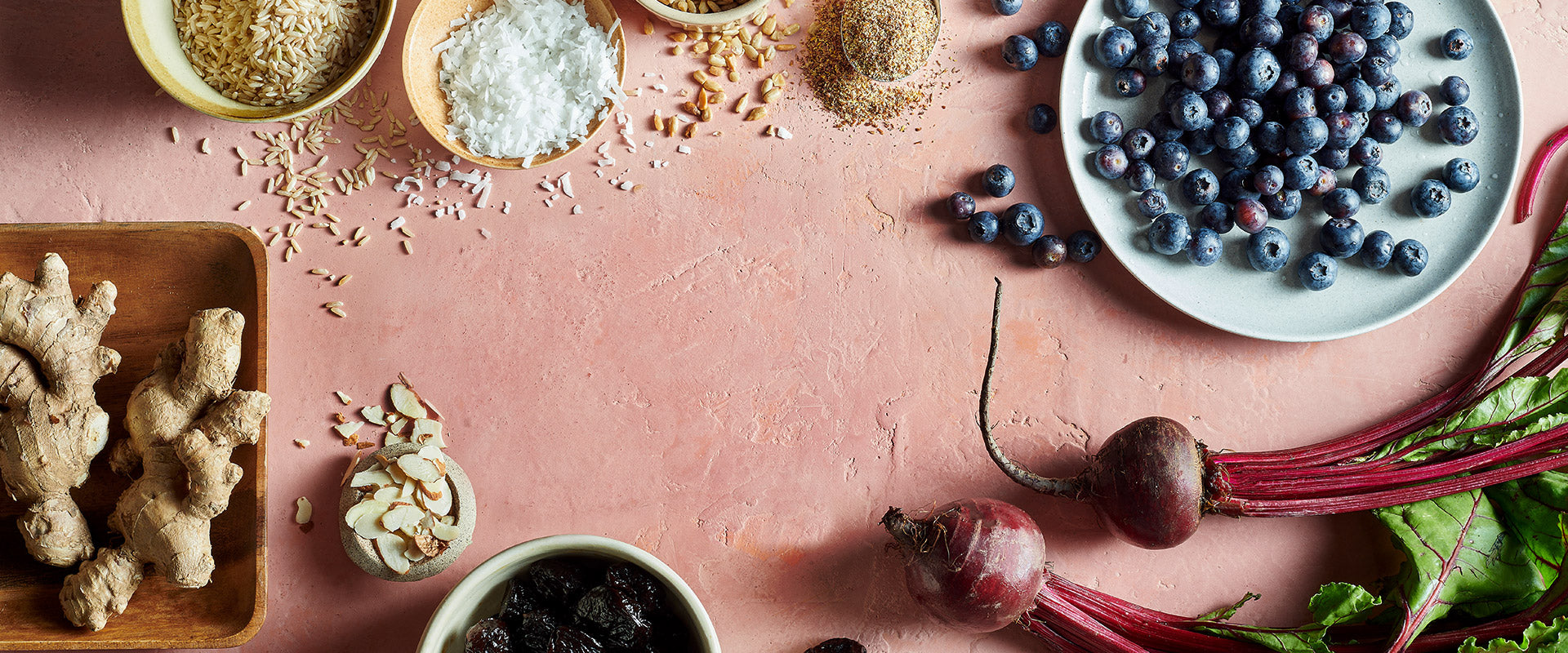 Spices, blueberries, and beets on a pink surface