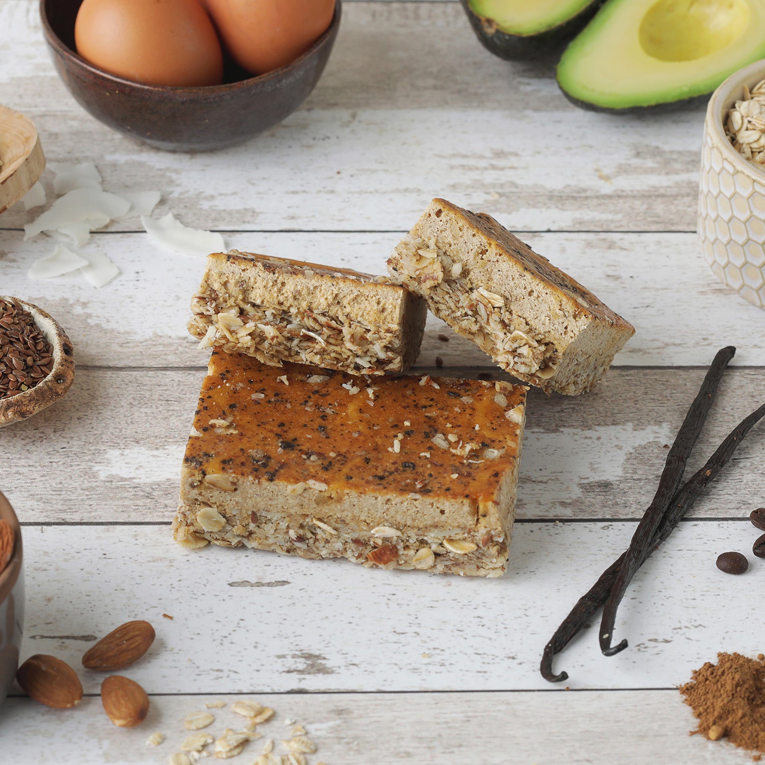 Image of C1 French Vanilla Protein Bar surrounded by ingredients like eggs, avocados, and almonds.