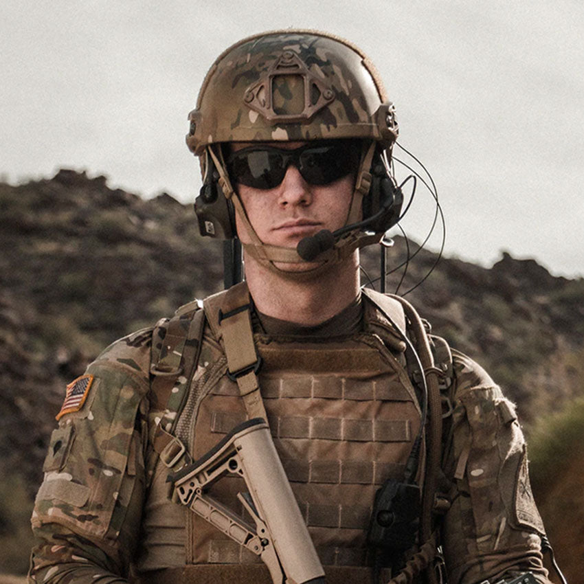Person in military gear with a rifle in a desert landscape