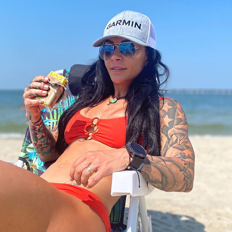 Ashley Horner eating a C1 bar on the beach.
