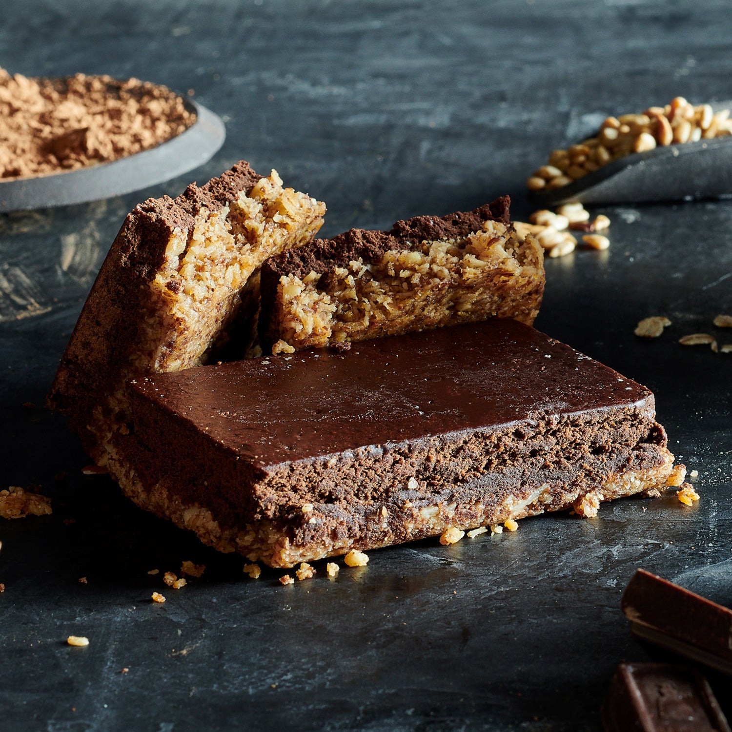 A high-protein nutrition bar with layers visible, showing the chocolate coconut almond flavor showing real ingredients such as oats and almonds.