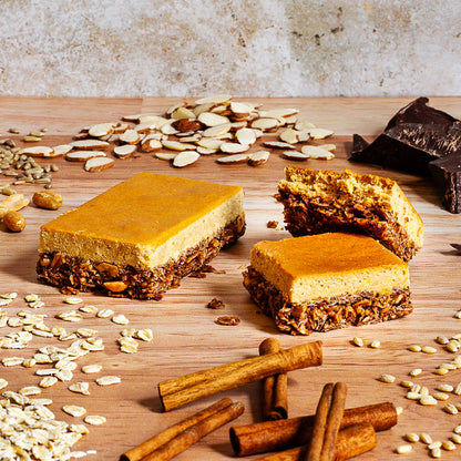 Condition One Peanut Butter Chocolate bars surrounded by ingredients such as chocolate, almonds, peanuts, and oats.